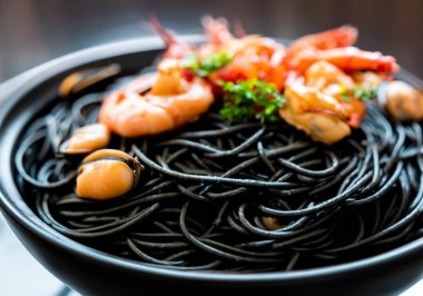 Siyah masadaki deniz mahsullü siyah spagettiyi kapat.