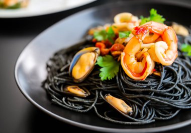 Siyah masadaki deniz mahsullü siyah spagettiyi kapat.