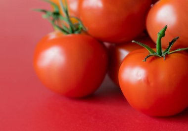 Kırmızı arka planda kırmızı domatesler, bulanık arkaplan