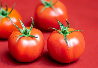 Kırmızı arka planda kırmızı domatesler, bulanık arkaplan