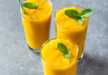 Tazeleyici ve sağlıklı mango smoothie uzun gözlüklü, bulanık suratlı