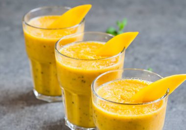 Tazeleyici ve sağlıklı mango smoothie uzun gözlüklü, bulanık suratlı