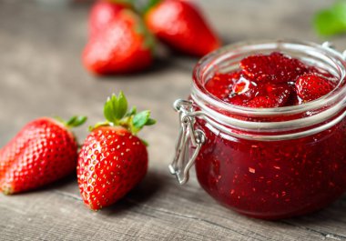 Cam kavanozdaki çilek reçelini taze berrie ile kapat.