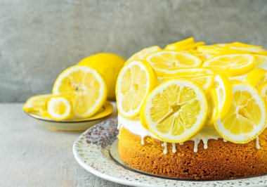 Limon dilimleriyle kaplı limonlu kek, bulanık bir arka grup.