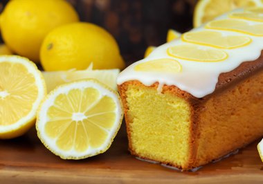 Limon dilimleriyle kaplı limonlu kek, bulanık bir arka grup.