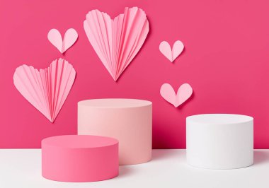 Güzel pembe sevgililer günü sahnesi üç farklı boyutta silindir podyum, kağıt kalpler, kopya spac