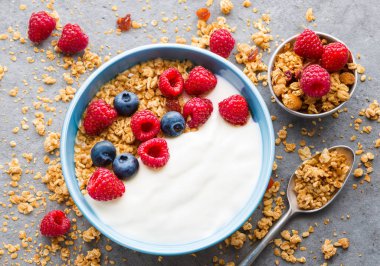 Granola ve böğürtlenli yoğurt kasesi, seçici odak.