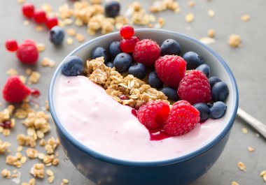 Granola ve böğürtlenli yoğurt kasesi, seçici odak.