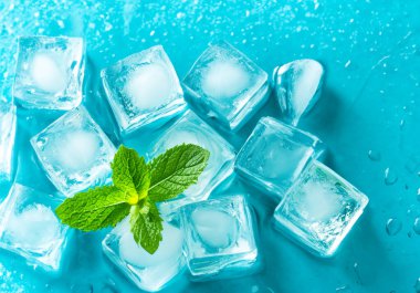 Mavi arkaplanda buz küpleri ve nane şekeri, seçici odak