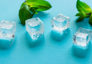 Mavi arkaplanda buz küpleri ve nane şekeri, seçici odak