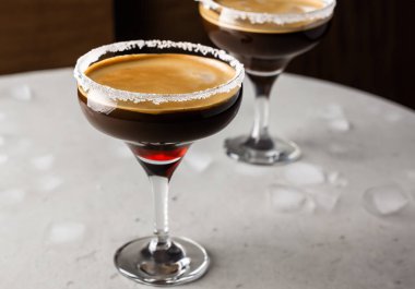 Masadaki bardağa espresso martini kokteyli.