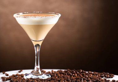 Masadaki bardağa espresso martini kokteyli.