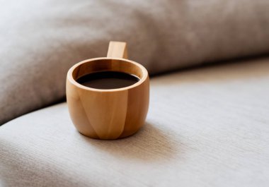 Odunsu kahve fincanını sıcak kanepeye koy.