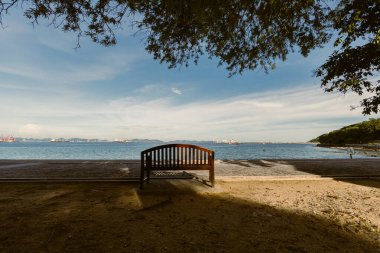 # Parktaki yazlık kumsalda boş bir bank #