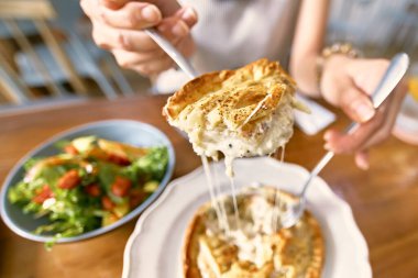 Yengeç eti, duble peynirli turta, ahşap masada.