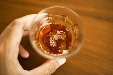 Birisi elinde bir kupa sade kahve tutuyor.