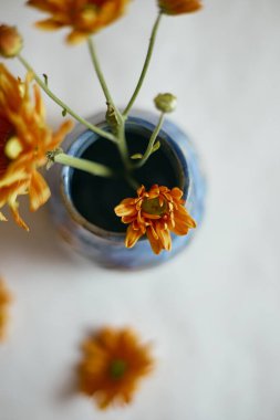 Bej arka planda çiçekli seramik vazo.