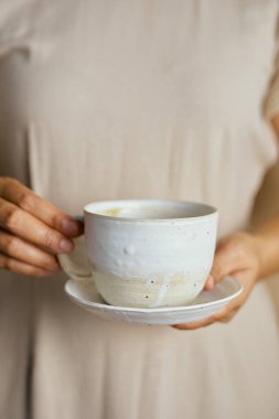 Dişi eller seramiğe tutunur  