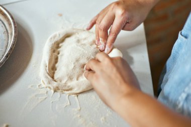 Eller pizza yapmak için hamur yoğurur, seçici odaklanma