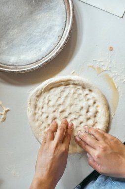 Eller pizza yapmak için hamur yoğurur, seçici odaklanma