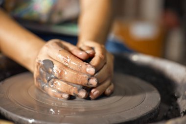 Çömlek tekeri üzerinde çalışan bir sanatçının elleri. Seçici Odak