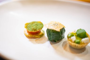 Zarif lokma büyüklüğünde aperatifler bir tabakta, enfes bir yemek, yaratıcı restoran yemeği konsepti.