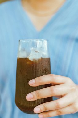 Hand 'in elinde bir bardak buzlu Americano ya da sırt kahvesi tutarken yaklaş.