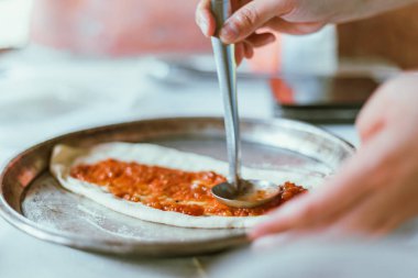 Pizza tavasına domates sosu serpiştirmek, seçici odaklanma