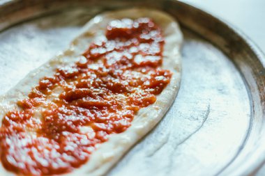 Pizza tavasına domates sosu serpiştirmek, seçici odaklanma