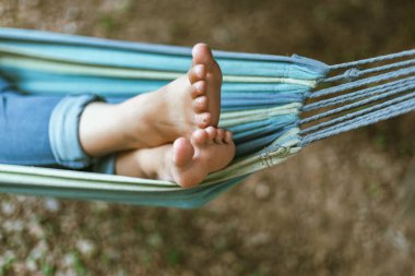 Mutlu genç kadın gardda bir hamakta dinleniyor.