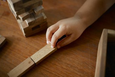 Yakın plan el ele tutuşup Jenga ya da Tumble kulesi tahta blok oyunu oynayacağız.