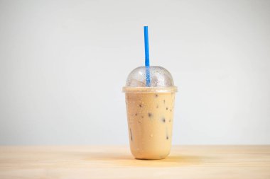 Buzlu kahve ya da kahve fincanı içinde ahşap masada kahve. Paket kahve, soğuk içecek..