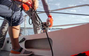 Yelkenli, teknedeki yelkeni emniyete almak. Tayfa yelkenlideki yelkeni daraltır. Tekne gezisi. Yüksek kalite fotoğraf