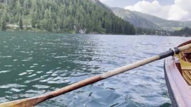 Yeşil dağlarla çevrili bir sandaldan güzel göl manzarası