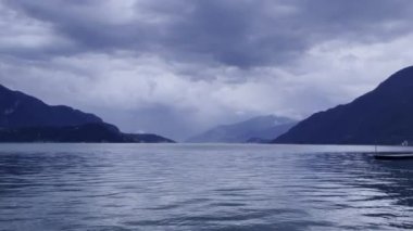 Sakin sular güzel yansıtır dağları ve dramatik bulutları arka planda