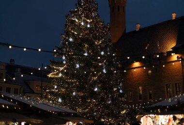 Güzel dekore edilmiş bir Noel ağacı Tallinn 'deki kış pazarını aydınlatıyor..