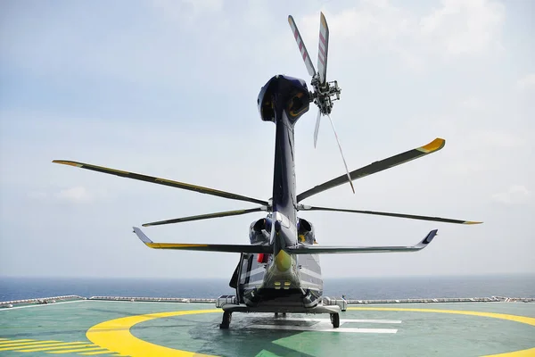 直升机着陆官与飞行员和副驾驶人员沟通 以提供地面服务 并作为飞行员所需的支持 直升机降落在甲板上的石油和天然气平台上 — 图库照片