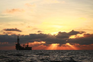 Petrol ve sondaj, gün batımı ve gün doğumuyla birlikte kıyıdan uzakta. Enerji ve enerji sektöründe petrol ve doğalgaz üretim platformu.