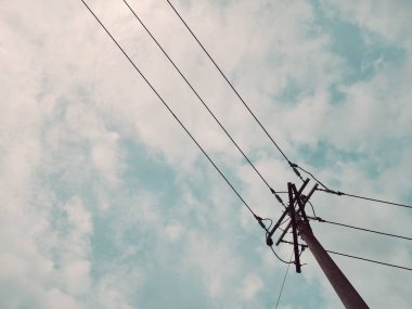 Elektrik direği elektrik kabloları ve telleri ile mavi gökyüzü arka plan