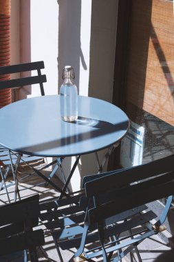 PARIS, FRANCE - 04 Nisan 2023: Paris 'te bir kafede masanın üzerinde bir şişe su. Geleneksel ücretsiz