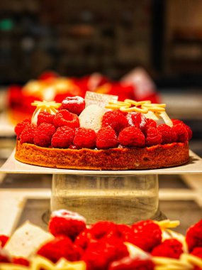 PARIS, FRANCE - October 06, 2024: Tart with raspberries. Cake on display in a pastry shop in Paris