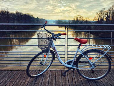 PARIS, FRANCE - 14 Aralık 2024: Sonbahar ormanlarında beyaz bir bisikletle yürümek.