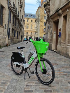 PARIS, FRANCE - 12 Nisan 2025: Lime velos yeşil motosikletleri kısa vadeli ulaşım, çevre dostu ve sağlıklı gündüz zamanı ihtiyacı olan müşteriler için