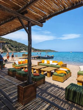 BONIFACIO, CORSICA - 30 Haziran 2025: Corsica 'da güzel bir tropikal plajda lüks bir restoran. Mavi gökyüzü ve turkuaz sular.