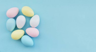 Pastel mavi arka planda renkli Paskalya yumurtaları. Yukarıdan bak. Yüksek kalite fotoğraf.