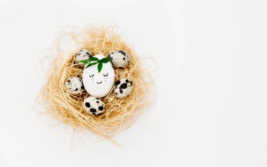 Beyaz arka planda bıldırcın yumurtaları olan şirin bir gülümseme ile Paskalya yumurtaları, asgari konsept. Paskalya tatili. Boşluğu kopyala. Paskalya pastası..