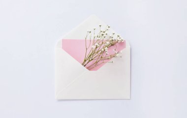 Beyaz zemin üzerinde beyaz zarf içinde çingeneler. Model, tebrik kartı, kadınlar günü, anneler günü, sevgililer günü, doğum günü, kopyalama alanı..