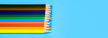 Mavi arkaplanda kopya alanı olan renkli kalemler, eğitim çerçevesi kavramı.