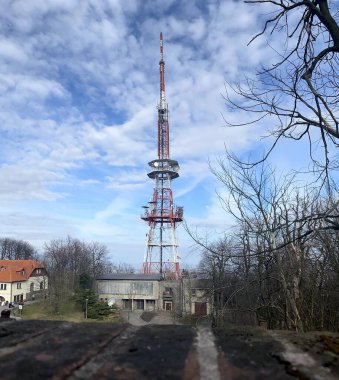Arka planda bulutlu ve mavi gökyüzü olan telekomünikasyon anteni