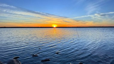 Bir martı sürüsüyle gölün üzerinde gün doğumu